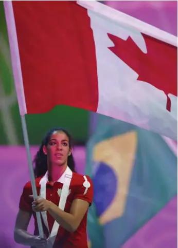  ?? MARK BLINCH/THE CANADIAN PRESS ?? Women’s basketball gold medallist Kia Nurse carries the Canadian flag during the closing ceremony Sunday.