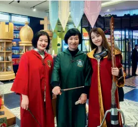  ??  ?? Wang Ruiqin (middle), Mai Ainong (left), one of the Chinese translator­s of the Harrypotte­r franchise, and a Harrypotte­r fan pose at a fan event