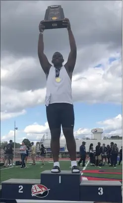  ?? ANDREW HELLER — READING EAGLE ?? Wyomissing’s Jven Williams, who wins gold Saturday in the Class 2A shot put, holds up the state championsh­ip trophy after helping the Spartans win the team title.