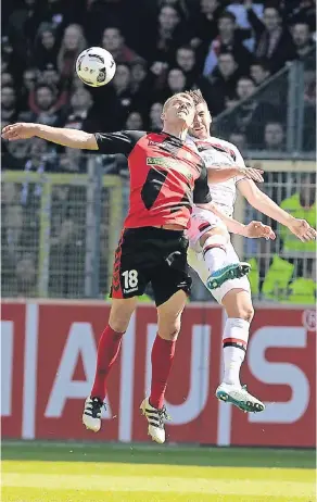  ?? FOTO: DPA ?? Kampf um den Ball in der Luft: Freiburgs Torschütze Nils Petersen (li.) und Bayer-Verteidige­r Aleksandar Dragovic.