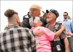  ?? Official White House Photo by Shealah Craighead ?? President Donald J. Trump embraces residents Friday as he visits a neighborho­od devastated by a tornado that touched down Sunday in Lee County, Ala.