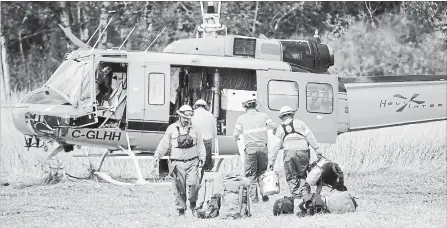  ?? NATHAN DENETTE THE CANADIAN PRESS ?? Mexican fire rangers load their gear into a helicopter to help fight the Parry Sound 33 forest fire, which has burnt thousands of hectares of land.