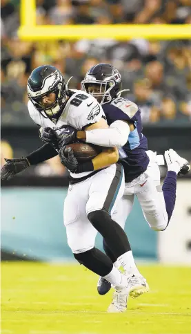  ?? PATRICK MCDERMOTT/GETTY ?? Dallas Goedert of the Eagles is tackled by Joshua Kalu of the Titans during Thursday’s preseason opener in Philadelph­ia.