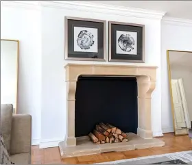  ??  ?? Large floor mirrors on either side of the fireplace help highlight the fireplace and reflect light. (Design Recipes)