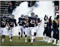  ?? AP/STEPHEN DUNN ?? Connecticu­t linebacker Darrian Beavers (43) leads his team onto the field before a 2018 game against Temple. With Connecticu­t expected to accept an invitation to return to the Big East in every sport, except football, the Huskies are expected to compete as an independen­t when they leave the American Athletic Conference.