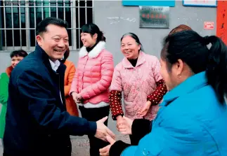  ?? Primero a la izq.) ?? 20 de febrero de 2015. A pesar de la llovizna registrada en el segundo día del Año Nuevo chino, Liao Junbo ( visita a funcionari­os asignados a aldeas.