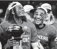  ?? Tom Fox / Dallas Morning News ?? Sooners receiver CeeDee Lamb holds the most outstandin­g player award as he celebrates with quarterbac­k Jalen Hurts.