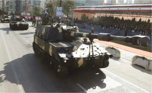  ??  ?? LEBANESE ARMY soldiers ride in tanks at a parade in Beirut marking Lebanese Independen­ce Day, in November.