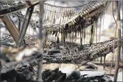  ?? JUSTIN SULLIVAN / GETTY IMAGES ?? Burned-out wine bottles sit on a rack at the fire-damaged Signarello Estate winery after a wildfire moved through the area on Monday in Napa, California.