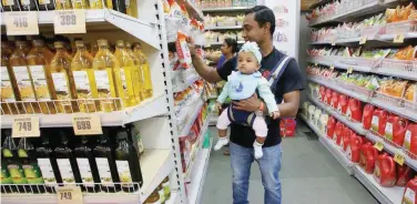  ?? Reuters ?? A customer carries his daughter as he buys goods at a store inside a shopping mall in Kolkata.