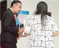  ??  ?? PEGUAM Mohd Al-Hafidz memberi penerangan kepada Khoo yang menghadapi tuduhan menghalang penjawat awam bertugas di Mahkamah Majistret Kota Kinabalu.