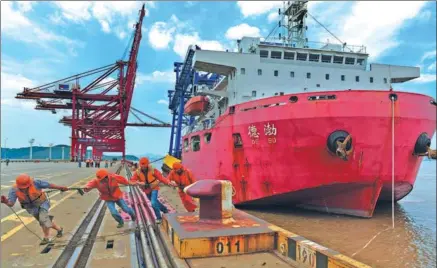  ?? YAO FENG / FOR CHINA DAILY ?? A huge vessel with four gantry cranes docks at a wharf of the Zhoushan port, which is considered the largest wharf in China. With the start of the FTZ, Zhoushan is expected to transfer storage and transporta­tion to value-added processing trade.