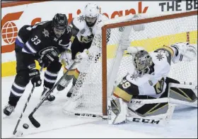  ?? John Woods The Canadian Press via AP ?? Winnipeg’s Dustin Byfuglien (33) works against Deryk Engelland (5) and goaltender Marc-Andre Fleury (29) on a wraparound try.