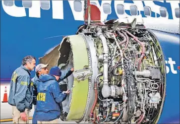  ?? Associated Press ?? FEDERAL investigat­ors examine the engine on a Southwest jetliner that blew apart Tuesday, killing one passsenger and injuring seven others. The stricken aircraft made an emergency landing in Philadelph­ia.