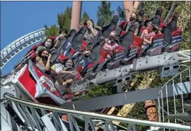  ?? Mel Melcon Los Angeles Times ?? PARKGOERS ride the Revolution at Six Flags Magic Mountain in Valencia on Friday. “It’s Day 2,” a park spokespers­on said. “We are still working out the bugs.”