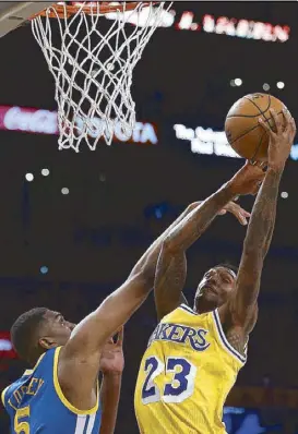  ?? AP ?? Los Angeles Lakers guard Lou Williams goes up for a shot against Golden State Warriors forward Kevon Looney during the second half of their game in Los Angeles.