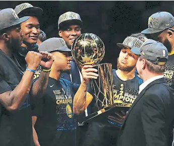  ?? FOTO: AFP ?? Stephen Curry mira detenidame­nte la copa que Golden State acaba de ganar. Es el tan buscado doblete de los Warriors, que superan a San Antonio (cinco anillos) y empatan con los Bulls (6).