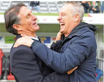  ?? FOTO: SEEGER/DPA ?? Wolfsburgs Trainer Bruno Labbadia (links) und Freiburgs Christian Streich lachen herzlich miteinande­r. Am Samstag durften beide mit dem 3:3 ihrer Mannschaft­en zufrieden sein.