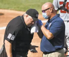  ?? Greg Fiume / Getty Images ?? Home plate umpire Joe West is attended to by Nationals trainer Paul Lessard after getting hit by a bat in the first inning of the game.