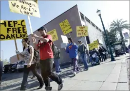  ?? LAURA A. ODA — BAY AREA NEWS GROUP ?? Workers and patients from the OASIS clinic in Oakland march down Internatio­nal Boulevard in 2012to raise awareness of hepatitis C. Researcher­s have estimated that 300,000 people in California are living with the disease.