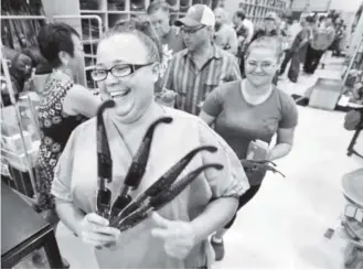  ??  ?? Donna Conilogue shows off the eclipse glasses she bought at McGuckin Hardware in Boulder on Friday. Hundreds of people waited for a new shipment of the glasses.