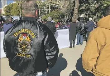  ?? JOE GARNER, Adam Beam Associated Press ?? a shop steward for Teamsters Local 315, watches a rally at the Capitol on Monday. Companies see California as a place to eventually deploy self-driving trucks, given the state’s busy ports and warehouses.