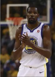  ?? BEN MARGOT — THE ASSOCIATED PRESS ?? Golden State Warriors forward Kevin Durant applauds a score during an NBA playoff game last season in Oakland, Calif.