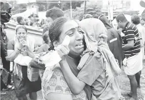  ?? — Gambar Reuters ?? PILU: Seorang wanita menangis sambil memeluk anaknya sejurus dipindahka­n dari kawasan banjir di Aluva, negeri selatan Kerala kelmarin.