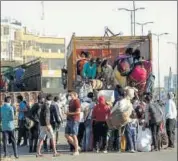  ??  ?? Migrant workers board a goods truck at the Gurugram-alwar national highway in Gurugram on Monday. PARVEEN KUMAR/HT PHOTO