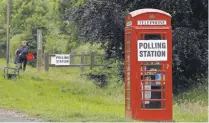  ?? ADRIAN DENNIS, AFP/GETTY IMAGES ?? A polling station sign is posted on a telephone booth outside the actual polling station at Rotherwick Hall on Thursday.