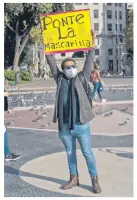  ?? AP ?? RECORDATOR­IO. Un activista en Barcelona invita al uso de cubrebocas.