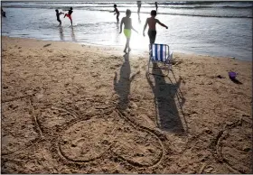  ?? (AP/Oded Balilty) ?? Heart shapes drawn in sand are seen June 12 as the sun sets over Tel Aviv’s beach.