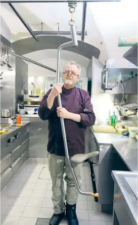  ??  ?? Schienen an der Decke, ein Bügel und ein Radlsattel: Mit der Stehhilfe kann der Salzburger Wirt Peter Lammer weiterhin kochen.