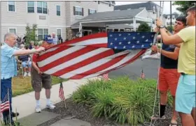  ?? PHOTOS BY JOHN STRICKLER — DIGITAL FIRST MEDIA ?? A flag raising ceremony was held at Keystone Villa at Douglassvi­lle Friday to commemorat­e Independen­ce Day which is on the 4th of July and also to welcome home Marine Corps brothers Adam and Greg Seanor. Cpl. Adam Seanor, in yellow shirt, returned home...