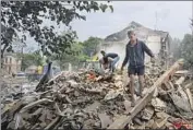  ?? Evgeniy Maloletka Associated Press ?? RESIDENTS search the rubble of an apartment building struck by a missile Saturday in Chuhuiv in Ukraine’s Kharkiv region. Three civilians were killed.
