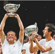  ?? AP ?? Poland’s Lukasz Kubot and Brazil’s Marcelo Melo proudly hold up their trophies after defeating Austria’s Oliver Marach and Croatia’s Mate Pavic in the men’s doubles final at Wimbledon on Saturday.