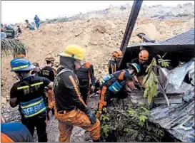  ?? AP ?? Emergency rescue workers search for survivors Thursday in the city of Naga.