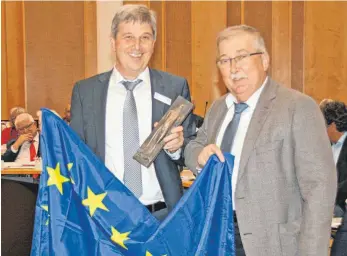  ?? FOTO: CLAUDIA STECKELER ?? Eine Europaflag­ge zum Abschied: Landrat Stefan Bär und SPD-Kreisrat Willi Kamm, der nach zehn Jahren aus dem Kreistag ausscheide­t.