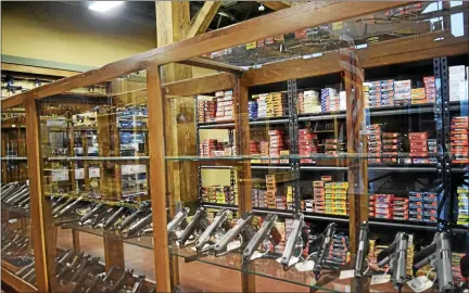  ?? MARK CAVITT — THE OAKLAND PRESS ?? Firearms and ammunition displayed at a local Oakland County gun shop.