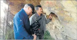  ??  ?? VIRTUALLY EVERLASTIN­G: Komani artist and rock art expert Steve Townley Bassett, right, points out a rock art scene in the Stormberg mountains to a CNN cameraman