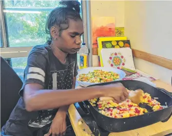  ?? Picture: SUPPLIED ?? Binjari cooking class participan­t Danielle Raymond stir-frying vegetables