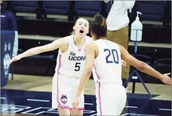  ?? David Butler II / USA Today ?? UConn’s Paige Bueckers (5) and Olivia Nelson-Ododa react after Bueckers hit a 3-pointer against South Carolina on Monday.