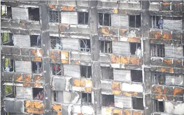  ??  ?? File photo shows workers inside the burnt out remains of the Grenfell tower.