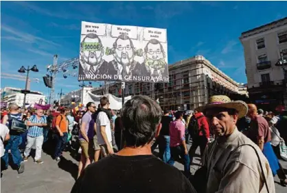  ?? —AFP ?? MADRID: Supporters of left-wing party Podemos hold banners and flags during a demonstrat­ion in Madrid calling for vote of no confidence against Spanish Prime Minister Mariano Rajoy.