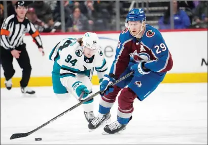  ?? ?? Colorado Avalanche center Nathan MacKinnon (front), drives down the ice with the puck as San Jose Sharks left wing Alexander Barabanov pursues in the first period of an NHL hockey game in Denver. (AP)