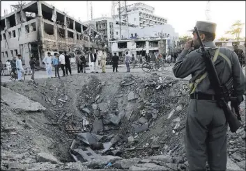  ?? Rahmat Gul The Associated Press ?? Security forces stand next to a crater created by an explosion May 31 in front of the German Embassy in Kabul, Afghanista­n. The suicide truck bomb hit a highly secure diplomatic area of Kabul, killing scores.