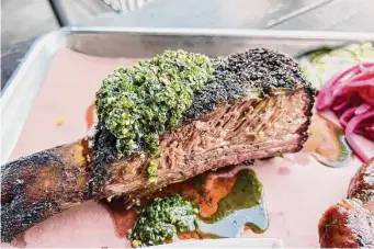  ?? Photos by J.C. Reid/Contributo­r ?? Beef rib with chimichurr­i sauce at Interstell­ar BBQ in Austin