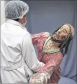  ?? MARTIN MEJIA/THE ASSOCIATED PRESS ?? An art restorer carries a damaged sculpture of Jesus Christ to be restored at the Ministry of Culture’s Restoratio­n Center in Cuzco, March 1, 2018. The team also restores delicate sculptures depicting Catholic martyrs made from wood and cloth which are...