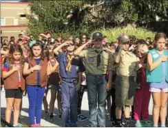  ?? GINGER RAE DUNBAR – DIGITAL FIRST MEDIA ?? Bradford Heights Elementary School Cub Scouts and Girl Scouts lead their classmates during the third annual Bradford Heights Patriot’s Flag Raising ceremony held at the school in West Bradford Township on Monday. The Scouts salute the American flag...