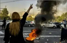  ?? Associated Press ?? Iranians protest the death of 22-year-old Mahsa Amini on Oct. 1 in Tehran, Iran. She died Sept. 16 after she was detained by the morality police. Iran on Sunday released security footage that it said came from its Evin Prison the night a fire that killed at least eight inmates broke out.